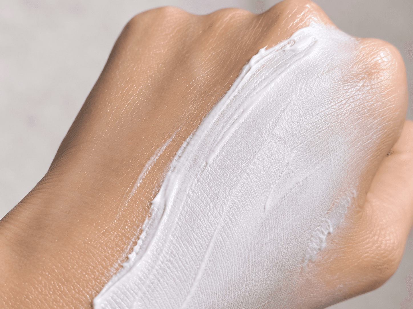 Protector solar mineral extendiéndose sobre el dorso de una mano